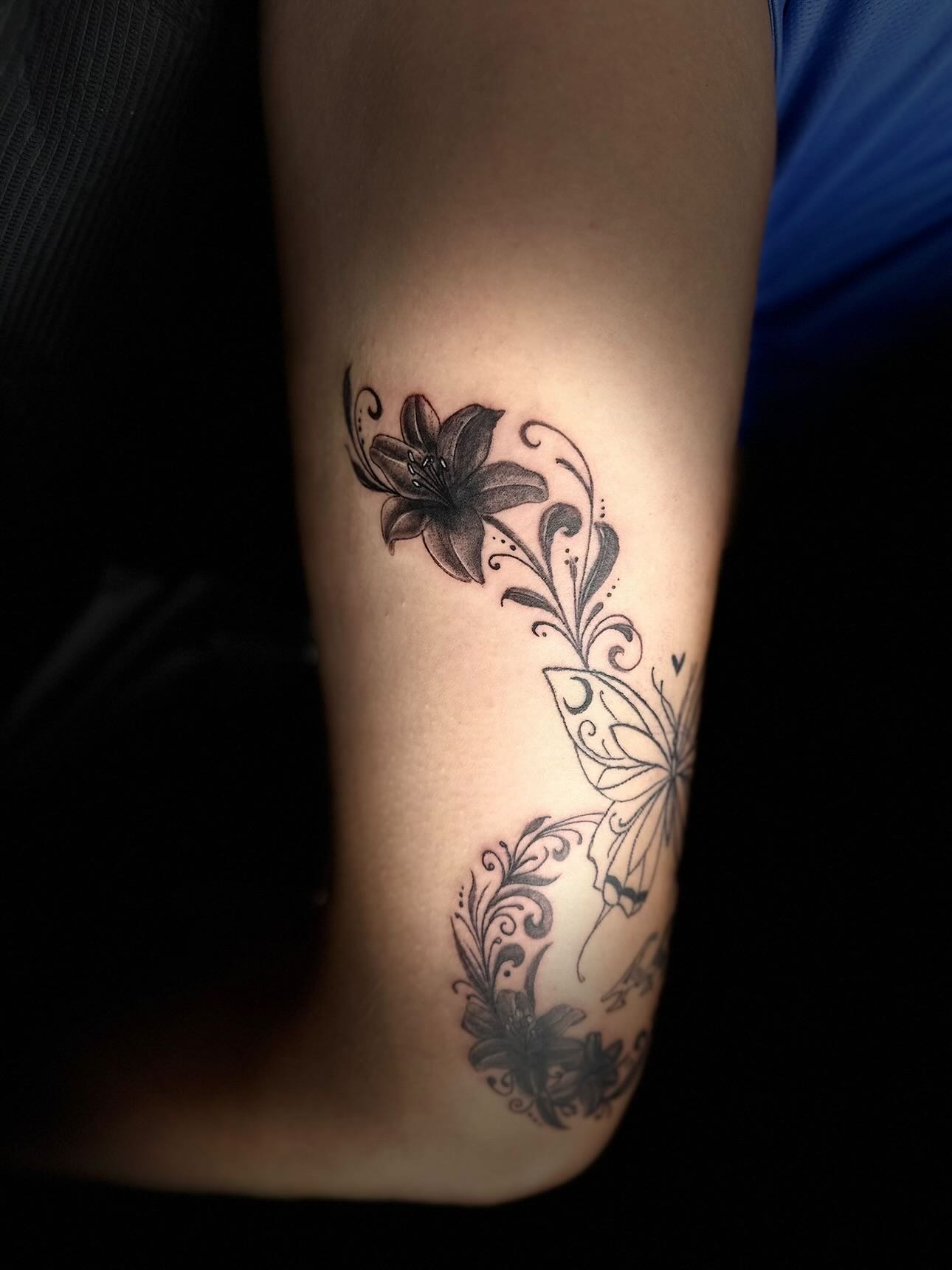 Black lily and butterfly flourish tattoo
