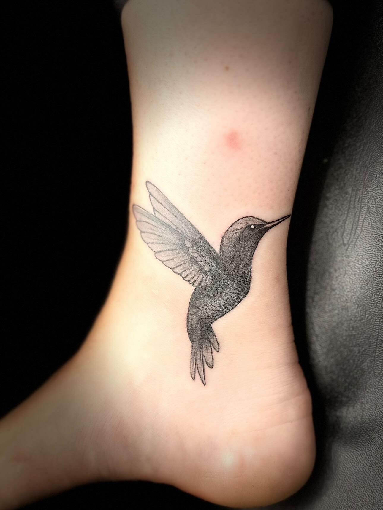 Detailed hummingbird ankle tattoo